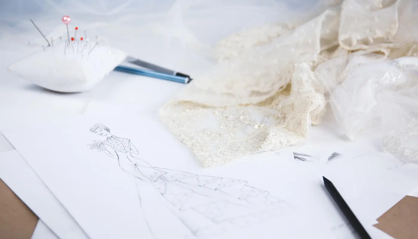 Croquis de robe et dentelle sur une table de couture